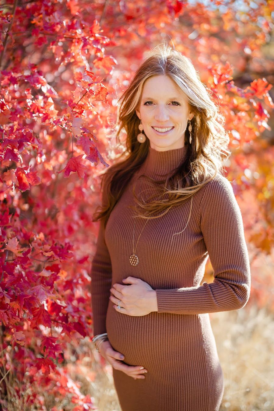 Sybille, pregnant with Mila, smiling among red autumn leaves